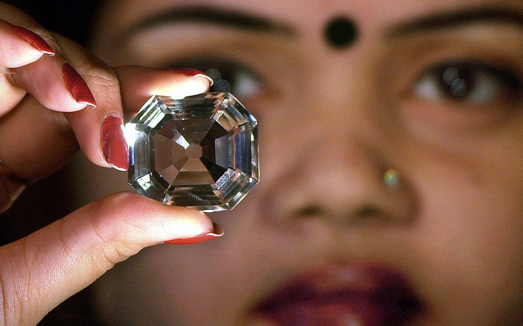 Picture of a woman contemplating the Koh-i-Noor diamond in her hand