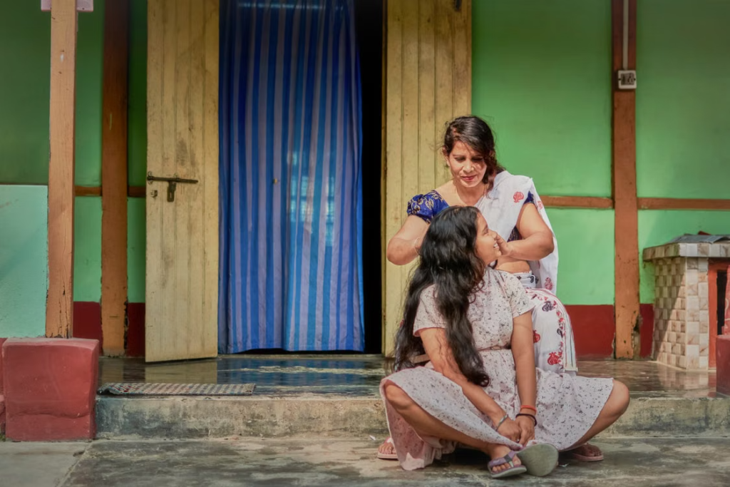 Mère prenant soin des cheveux de sa fille, un geste associé au champi indien