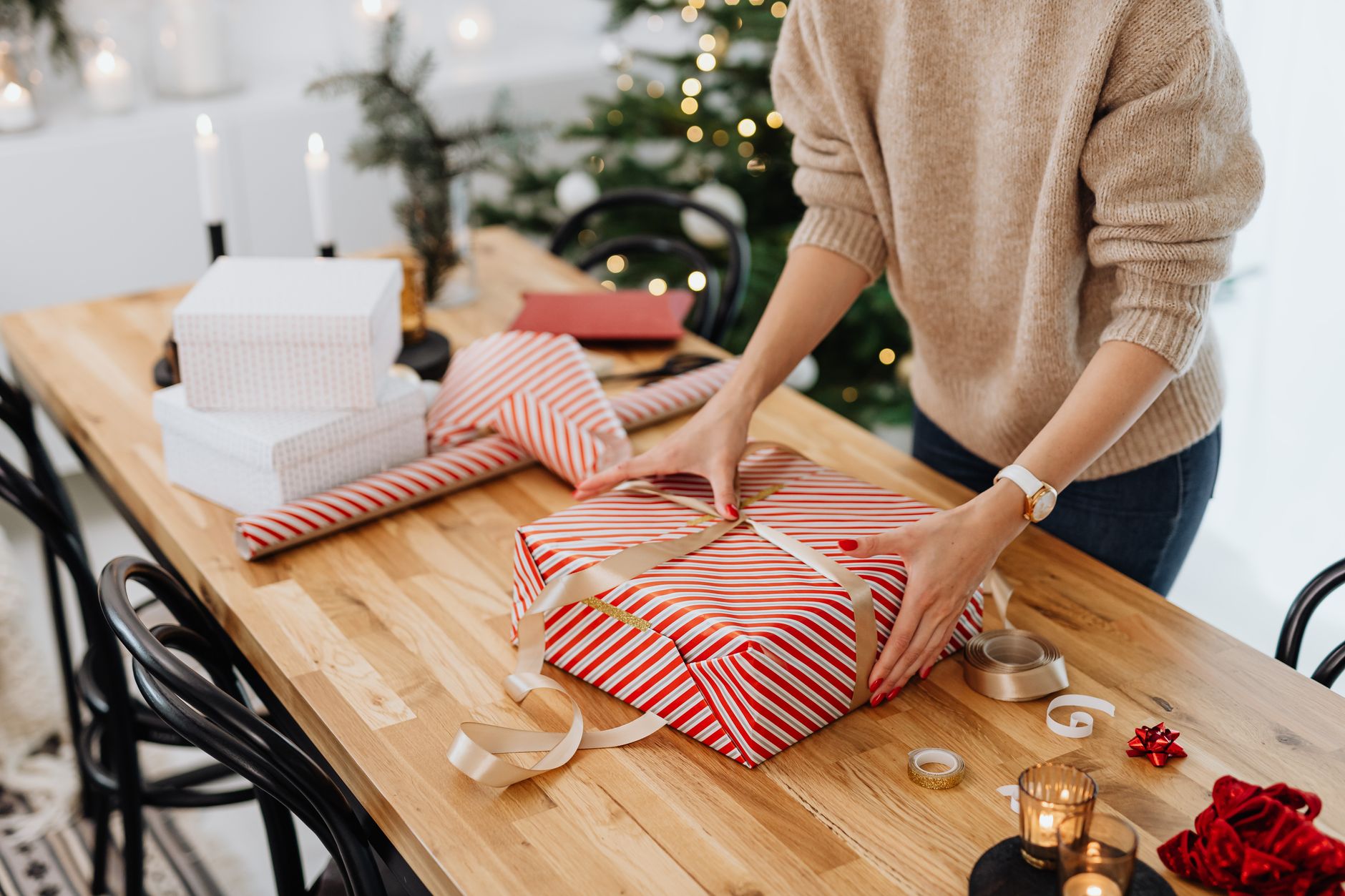 woman packing christmas presents on table